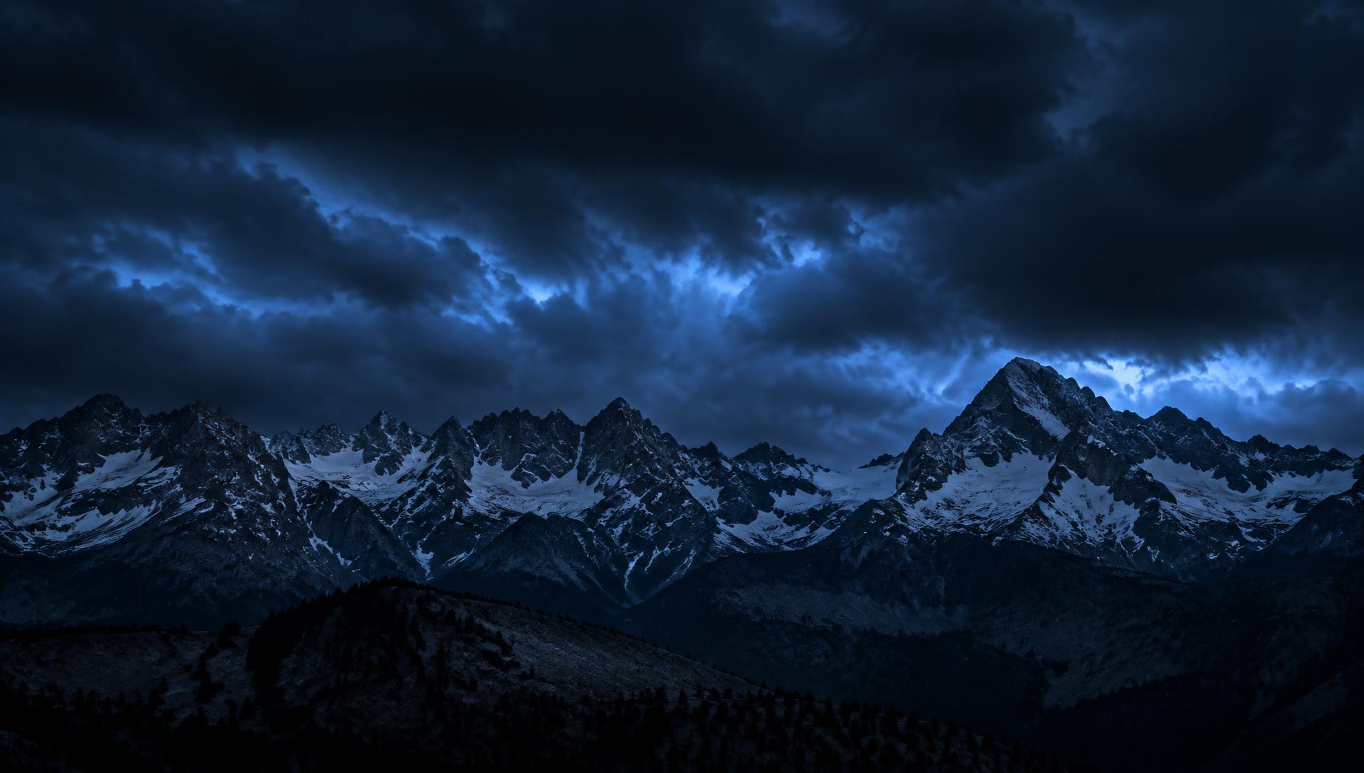 Jagged mountain range under a dark storm sky
